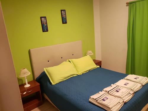 um quarto com uma cama azul e almofadas amarelas em Gala em Paso de los Libres