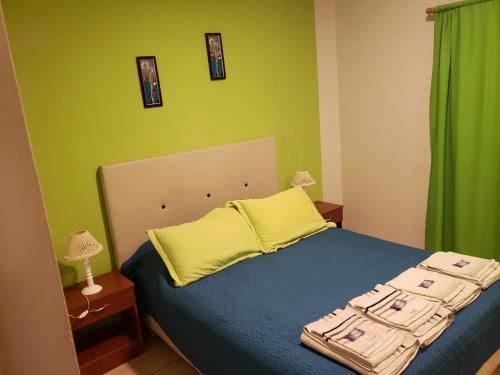 Un dormitorio con una cama azul con almohadas amarillas en Gala, en Paso de los Libres