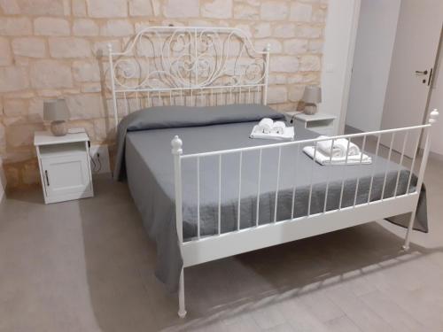 a bedroom with a white bed with shoes on it at Il Carrubo Holiday House in Scicli