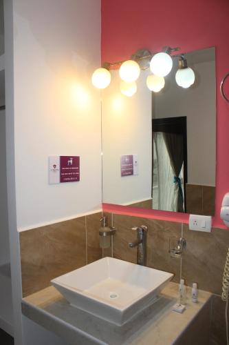 a bathroom with a white sink and a mirror at Hotel Boutique La Orquidea in Coatepec