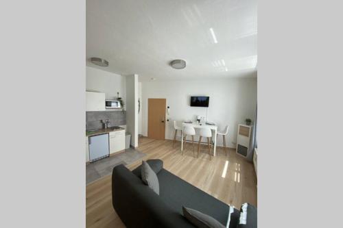 a living room with a couch and a table and a kitchen at Gemütliche Ferienwohnung in zentraler Lage in Erfurt