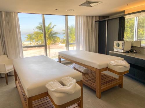 a room with a table and a kitchen with a view of the ocean at Hotel Nacional Rio de Janeiro in Rio de Janeiro