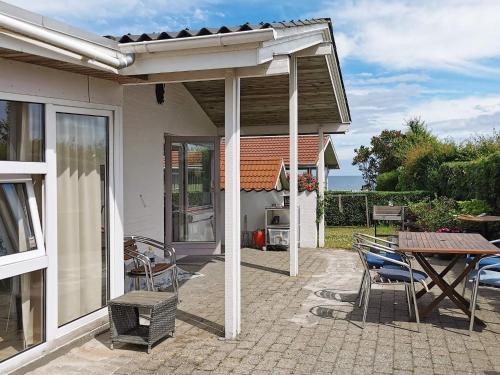 eine Terrasse mit einem Tisch, Stühlen und einem Pavillon in der Unterkunft 6 person holiday home in Malling in Malling