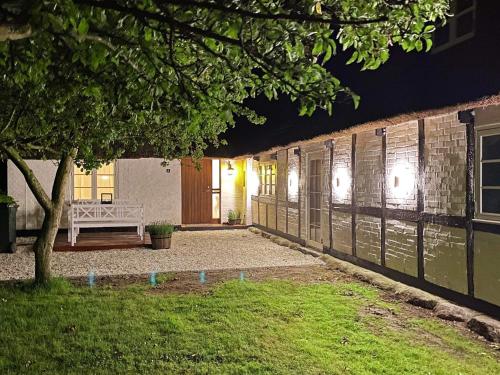 un patio de una casa por la noche con un banco en 6 person holiday home in Gedser, en Gedser