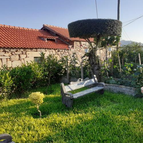 a garden with a bench in the grass at Vivenda Agostinho (Casa de Férias) in Arcos de Valdevez