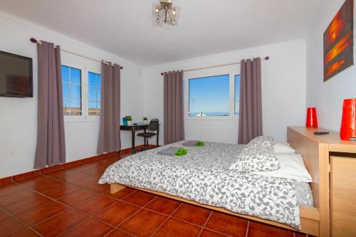 sypialnia z łóżkiem, biurkiem i oknami w obiekcie Casa Buena w Tías