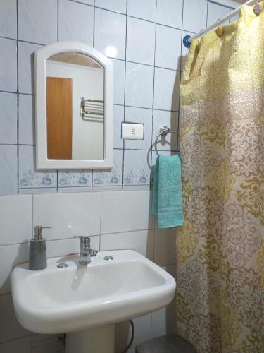 a bathroom with a sink and a mirror and a shower at Hostal Ayni in San Pedro de Atacama