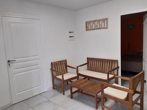 two chairs and a bench next to a door at La Poulette amazonienne in La Mauny