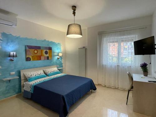 een slaapkamer met een blauw bed en een bureau bij B&B Angelina in Minturno