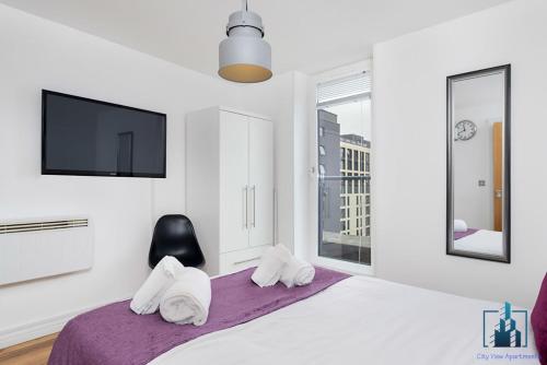 een slaapkamer met een bed, een tv en handdoeken bij Birmingham City Centre City View Apartments Central very close to Bullring in Birmingham