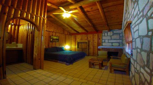 a bedroom with a bed and a fireplace in a cabin at Hotel Mansion Tarahumara in Areponapuchi