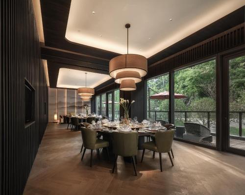 a dining room with a table and chairs and windows at Ahn Lan Xinchang in Xinchang