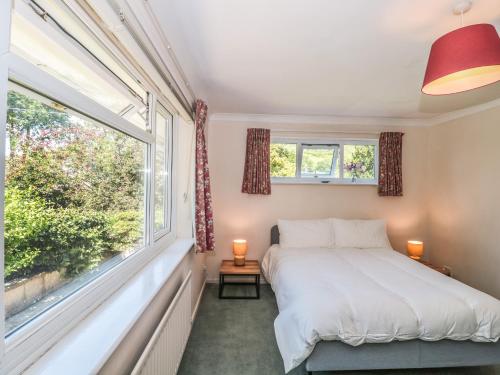 a bedroom with a bed and a large window at Skylark in Weymouth