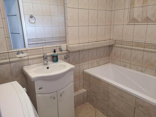 een badkamer met een wastafel, een bad en een toilet bij Via VOLTA 3 bedroom Apartment in Płock