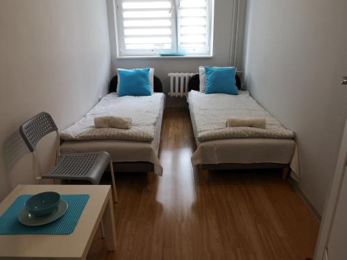 een kleine kamer met 2 bedden en een tafel bij Via VOLTA 3 bedroom Apartment in Płock