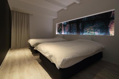 ein Schlafzimmer mit 2 Betten und einem großen Wandgemälde in der Unterkunft abrAsus hotel Fuji in Narusawa