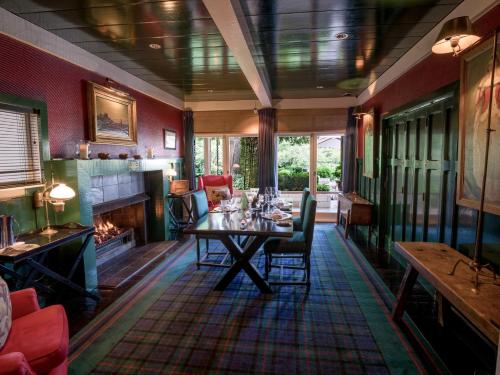 a dining room with a table and a fireplace at Huka Lodge in Taupo