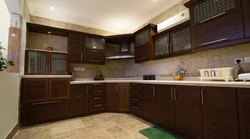 a large kitchen with wooden cabinets and white appliances at شاليه اوتار Strings Chalet in Riyadh
