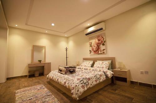 1 dormitorio con cama y espejo en شاليه اوتار Strings Chalet, en Riad