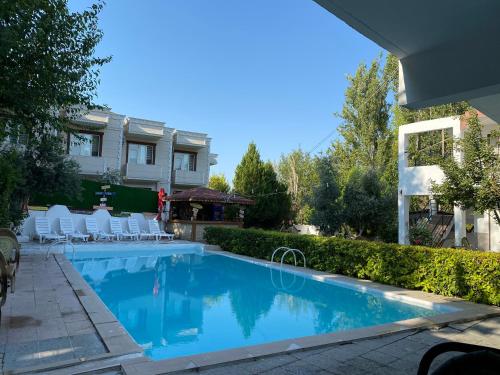 a swimming pool in a yard with chairs and a house at Sunrise Aya Hotel in Pamukkale