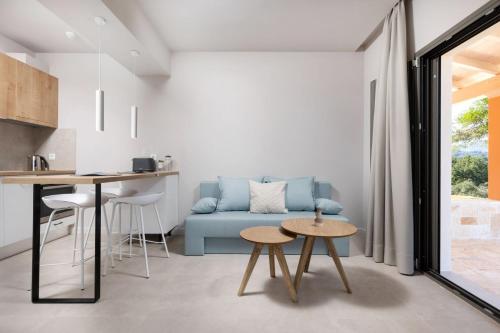 a living room with a blue couch and a table at Onore Luxury Suites in Kato Korakiana