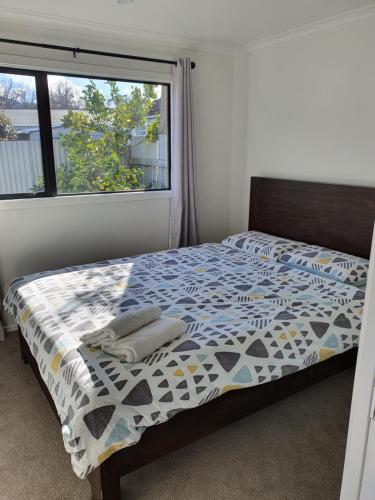 1 dormitorio con cama y ventana en Modern 1 bedroom guest house, en Upper Hutt