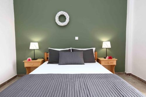 a bedroom with a large bed with two nightstands and two lamps at Sofia Apartments - Kantia in Kandia