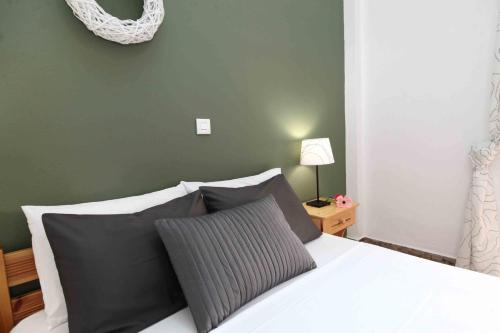 a bedroom with a bed with black and white pillows at Sofia Apartments - Kantia in Kandia