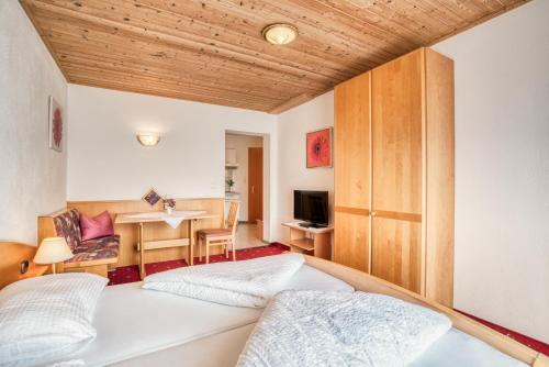 a bedroom with a bed and a dining room at Pension Weirather in Imst
