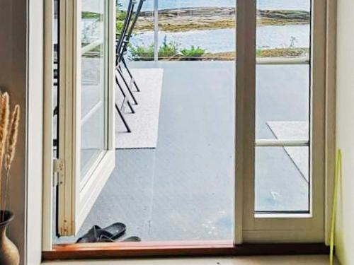 an open door to a balcony with a view of the ocean at Seaside Serenity in Hardangerfjord-By Traum in Tyrvikbygd