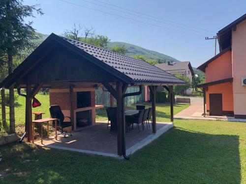 a gazebo with a table and chairs in a yard at Plitvice Family Apartment in Korenica