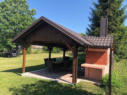 a gazebo with a table and a fireplace at Plitvice Family Apartment in Korenica