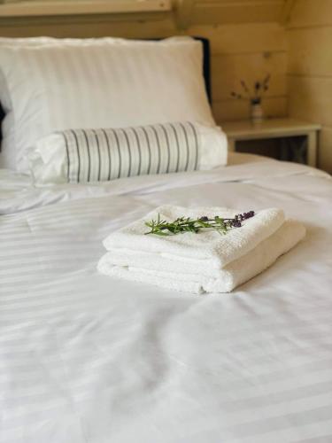 a stack of towels on a white bed at Dom z bala balia in Biskupiec