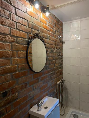 a bathroom with a brick wall and a mirror at ЧерникаЗемляника in Turgoyak