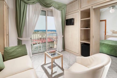 a living room with a couch and a bed and a window at Hotel Lido in Gabicce Mare