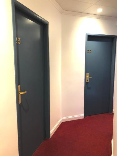 two doors in a room with a red carpet at Hôtel Porte Mars Reims Gare Centre Arena in Reims