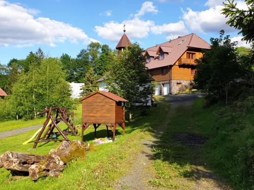 ein Holzhaus vor einem Haus in der Unterkunft König-in in Hojsova Stráž