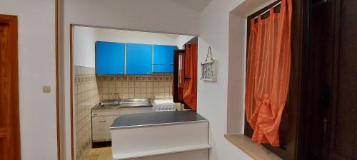 a small kitchen with blue cabinets and a counter at Isola Rossa Appartamenti Standard in Isola Rossa
