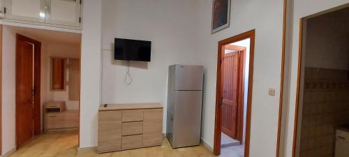 eine Küche mit einem Kühlschrank und einem TV an der Wand in der Unterkunft Isola Rossa Appartamenti Standard next to the beach in Isola Rossa