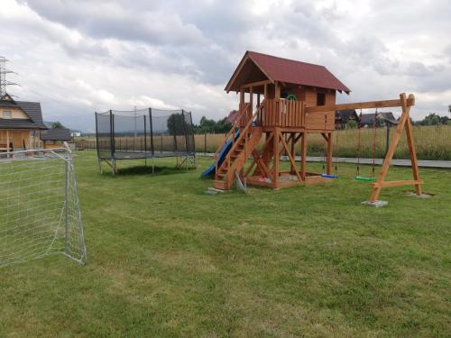 a playground with a slide and a playset at Domki Szarotki in Groń