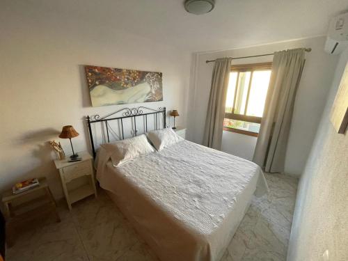- une chambre avec un lit blanc et une fenêtre dans l'établissement PARAISO DEL MEDANO ,CENTRICO, à El Médano