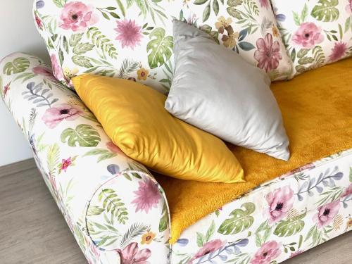 a floral couch with two pillows on it at New with a View - Spectacular Views in Every Direction in Hévíz