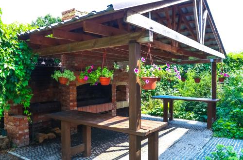a wooden bench under a pergola with potted plants at Fazenda in Sumy
