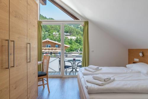 sypialnia z łóżkiem i widokiem na balkon w obiekcie Fourteen Zell am See S&P by All in One Apartments w mieście Zell am See