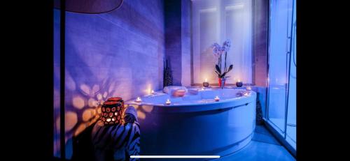 a bathroom with a tub with candles in it at Corso Suite 107 Rooms Wellness & Spa in Rome