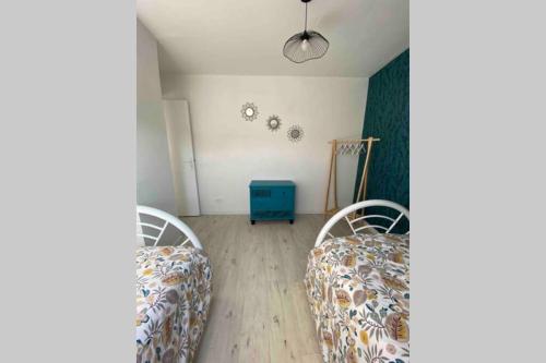 a bedroom with two beds and a blue cabinet at Chez Pat&Fred in Balnot-la-Grange
