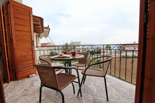 a patio with a table and chairs on a balcony at Sofia Apartments - Kantia in Kandia