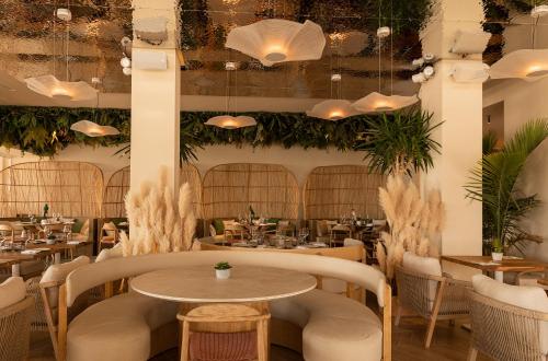 a restaurant with tables and chairs and potted plants at Hotel Boutique Sabbia Valencia in Valencia