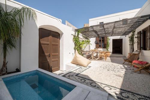 a courtyard with a swimming pool in a house at Lindian Plumeria in Líndos