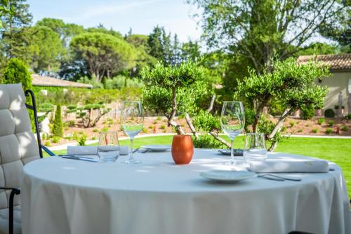 a white table with wine glasses on top of it at Le Vallon de Valrugues & Spa in Saint-Rémy-de-Provence